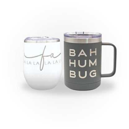 Set of engraved drinkware: a white wine tumbler with "Falalalala" and a gray mug with "BAH HUM BUG."